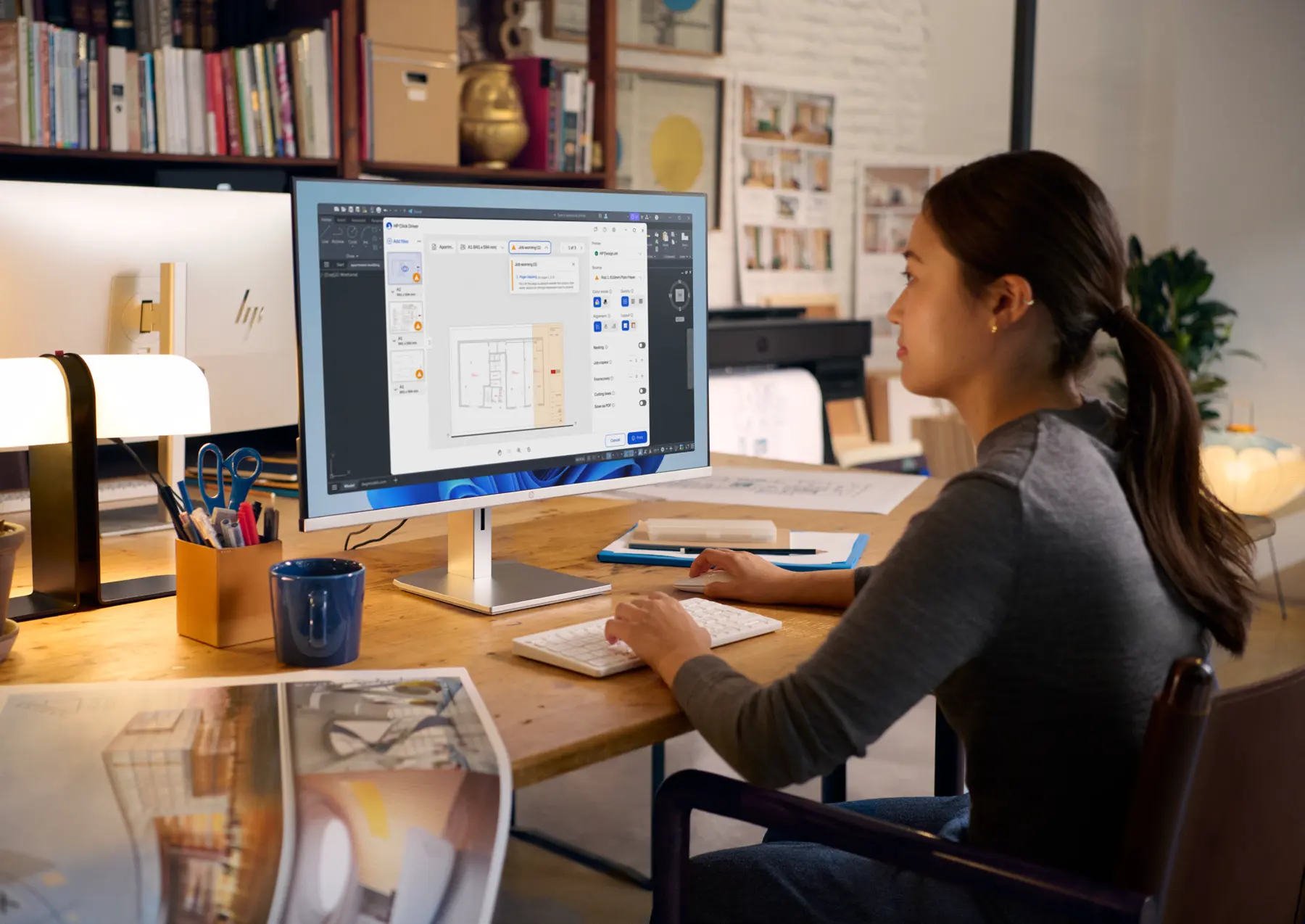 Designer al lavoro accanto a un plotter HP DesignJet